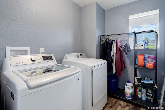 11038 Unity Ln, Commerce City, CO 80022 - laundry area featuring washing machine and clothes dryer, wood finished floors, and a textured wall