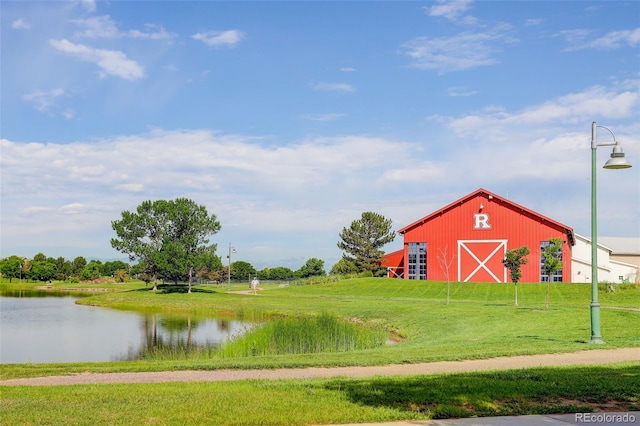 11038 Unity Ln, Commerce City, CO 80022 - view of home's community with a barn, a lawn, a water view, an outbuilding, and a detached garage
