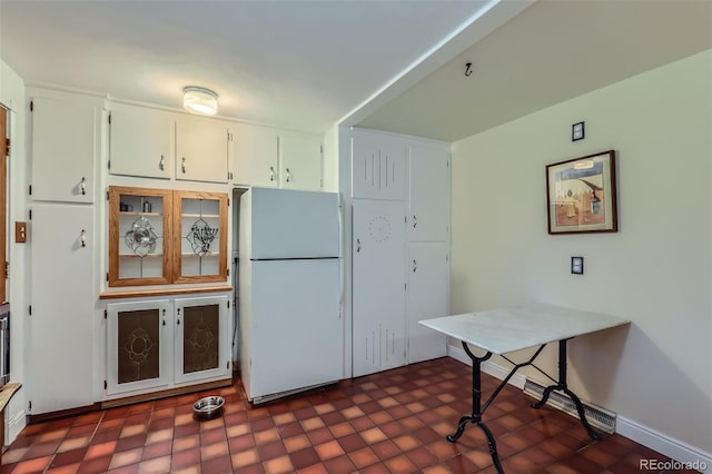 6260 W 45th Pl, Wheat Ridge, CO 80033 - kitchen featuring freestanding refrigerator, dark floors, white cabinets, and baseboards