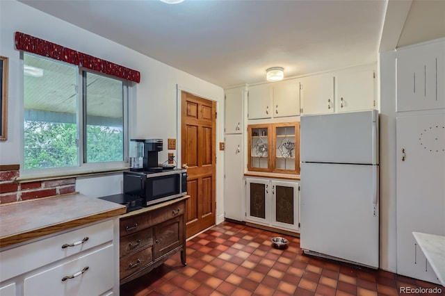 6260 W 45th Pl, Wheat Ridge, CO 80033 - kitchen with freestanding refrigerator, stainless steel microwave, white cabinetry, light countertops, and a desk