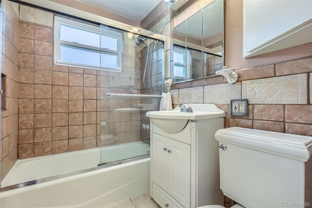 6260 W 45th Pl, Wheat Ridge, CO 80033 - bathroom with tile walls, vanity, bath / shower combo with glass door, toilet, and tile patterned floors