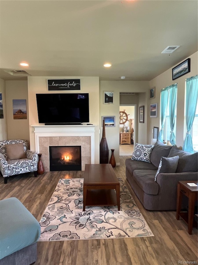 3892 Hackberry St, Wellington, CO 80549 - living area featuring wood finished floors, a tiled fireplace, and recessed lighting
