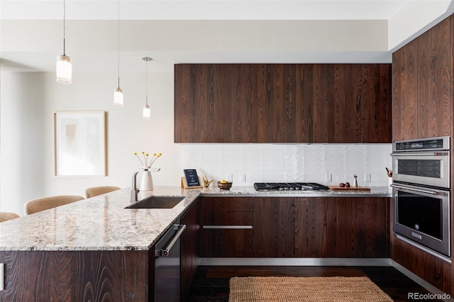 kitchen featuring modern cabinets, dark brown cabinetry, appliances with stainless steel finishes, and a peninsula