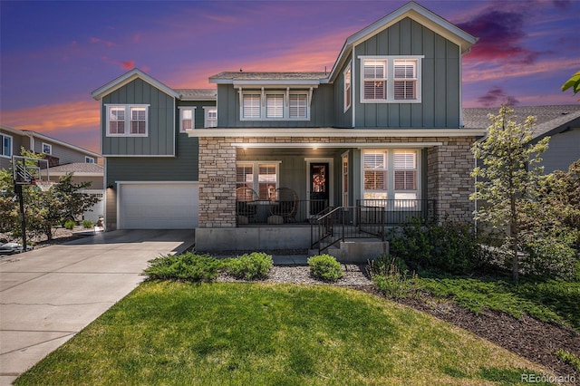 9380 Bear River St, Littleton, CO 80125 - view of front facade featuring board and batten siding, an attached garage, driveway, a porch, and a front lawn