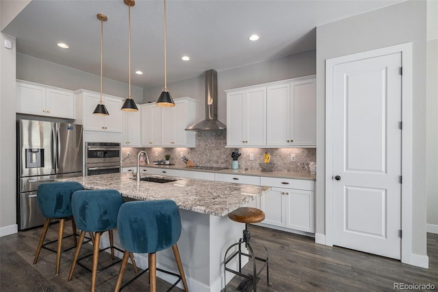 9380 Bear River St, Littleton, CO 80125 - kitchen featuring stainless steel appliances, wall chimney exhaust hood, a sink, dark wood-style floors, and decorative backsplash
