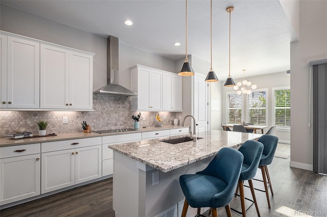 9380 Bear River St, Littleton, CO 80125 - kitchen with wall chimney range hood, a sink, black electric stovetop, dark wood-style flooring, and backsplash