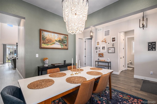 9380 Bear River St, Littleton, CO 80125 - dining room featuring a chandelier, dark wood-style flooring, and baseboards