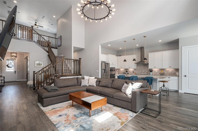 9380 Bear River St, Littleton, CO 80125 - living area with dark wood-style flooring, stairway, a chandelier, ceiling fan, and a high ceiling