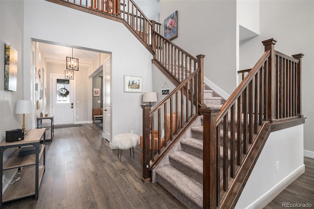 9380 Bear River St, Littleton, CO 80125 - stairs with wood finished floors, baseboards, a chandelier, and a high ceiling