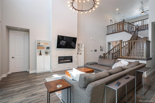 9380 Bear River St, Littleton, CO 80125 - living area featuring a high ceiling, wood finished floors, baseboards, stairway, and a glass covered fireplace