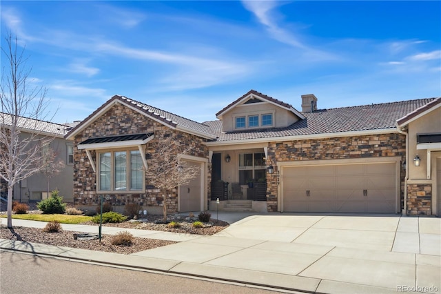craftsman house featuring stone siding, an attached garage, driveway, and a tile roof