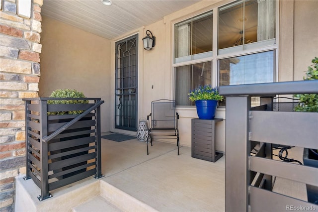 entrance to property with a porch and stone siding