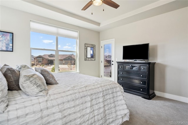 bedroom with carpet flooring, baseboards, a ceiling fan, and a raised ceiling