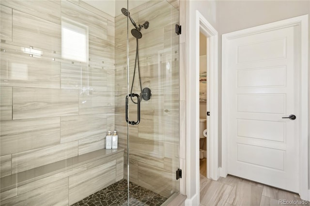 bathroom with a shower stall and toilet