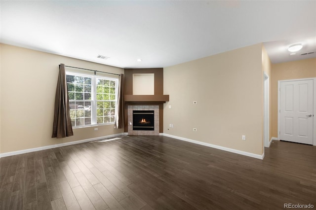 4064 S Carson St Unit 101, Aurora, CO 80014 - unfurnished living room featuring dark wood-type flooring and a tiled fireplace