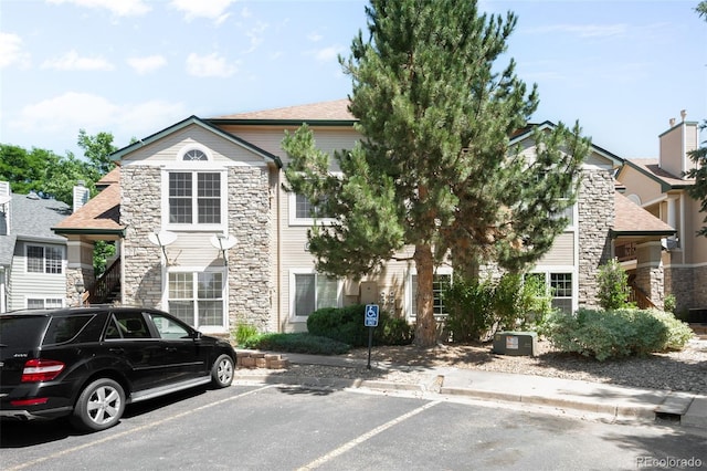 4064 S Carson St Unit 101, Aurora, CO 80014 - view of front of house featuring stone siding and uncovered parking