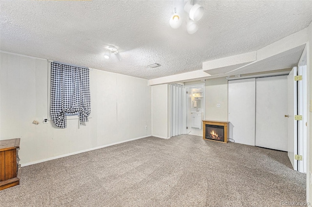 8002 Field Ct, Arvada, CO 80005 - finished below grade area featuring a glass covered fireplace, a textured ceiling, and carpet