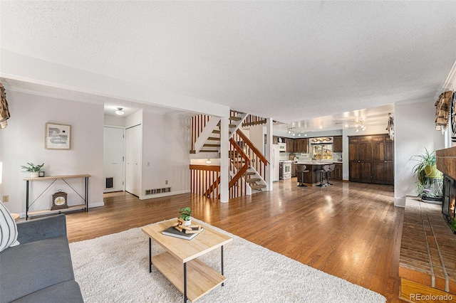 8002 Field Ct, Arvada, CO 80005 - living room featuring wood finished floors, stairway, a textured ceiling, and a chandelier