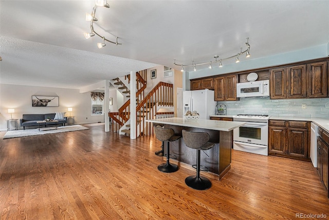 8002 Field Ct, Arvada, CO 80005 - kitchen with white appliances, open floor plan, a center island, and light countertops