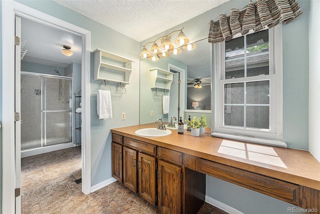 8002 Field Ct, Arvada, CO 80005 - full bath featuring a shower stall, a textured ceiling, double vanity, ceiling fan, and stone finish floors