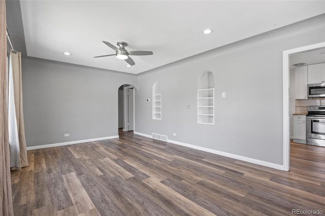2582 S Uno Way, Denver, CO 80219 - empty room featuring arched walkways, a ceiling fan, recessed lighting, dark wood finished floors, and built in shelves