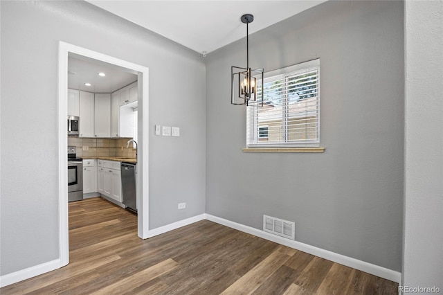 2582 S Uno Way, Denver, CO 80219 - unfurnished dining area featuring dark wood-type flooring and a chandelier