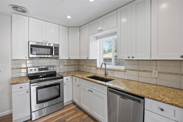2582 S Uno Way, Denver, CO 80219 - kitchen with stainless steel appliances, white cabinets, dark wood finished floors, and recessed lighting