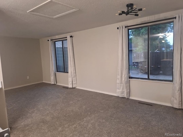 6207 W 92nd Pl, Westminster, CO 80031 - empty room featuring a textured ceiling, dark colored carpet, and attic access
