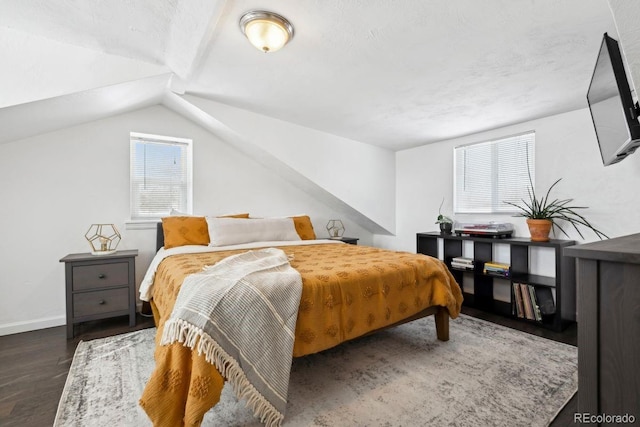 bedroom featuring dark hardwood / wood-style flooring, lofted ceiling, and a textured ceiling