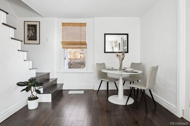 dining space featuring stairs, baseboards, and wood finished floors