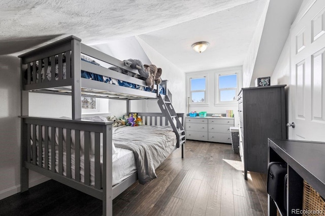 bedroom with a textured ceiling and wood finished floors
