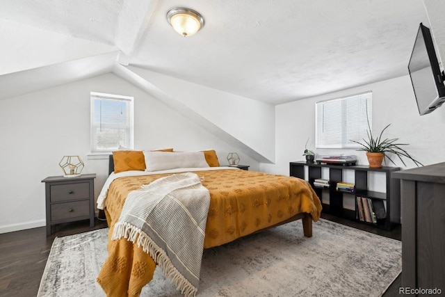bedroom with baseboards, vaulted ceiling, and wood finished floors