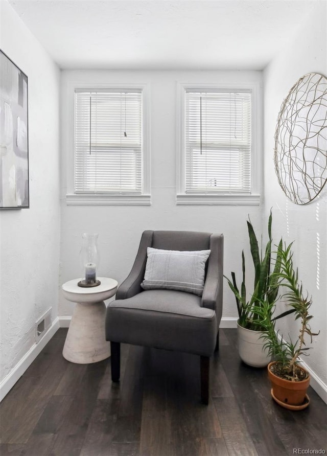 sitting room featuring baseboards, visible vents, plenty of natural light, and wood finished floors