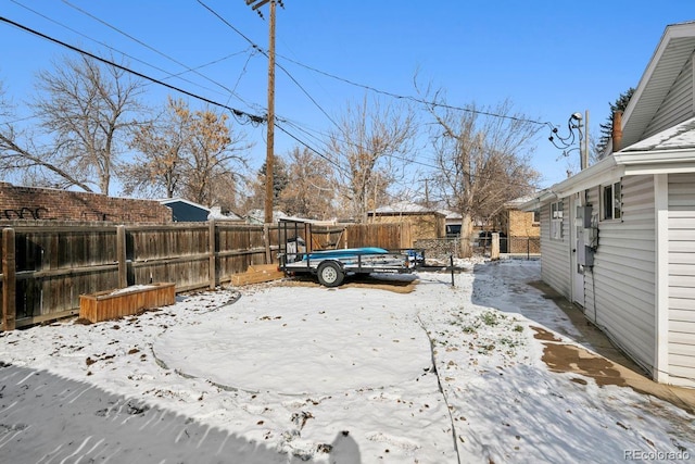 yard covered in snow featuring a fenced backyard