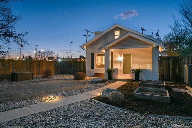 view of front of home with a garden and fence