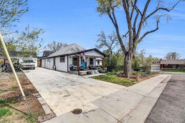 8885 W 64th Pl, Arvada, CO 80004 - view of front of house with concrete driveway, a porch, and fence