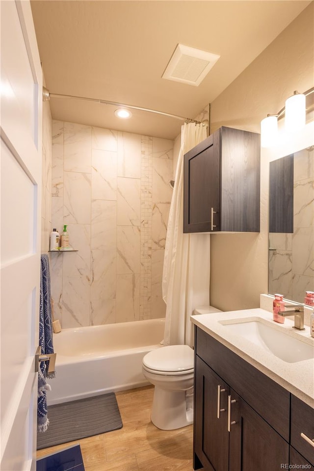 full bathroom with shower / tub combo, hardwood / wood-style floors, vanity, and toilet