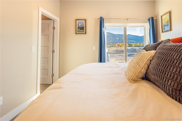 bedroom with access to outside and a mountain view