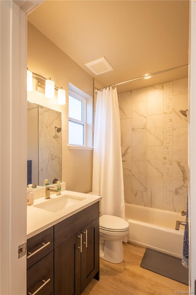 full bathroom featuring toilet, vanity, hardwood / wood-style floors, and shower / bath combination with curtain