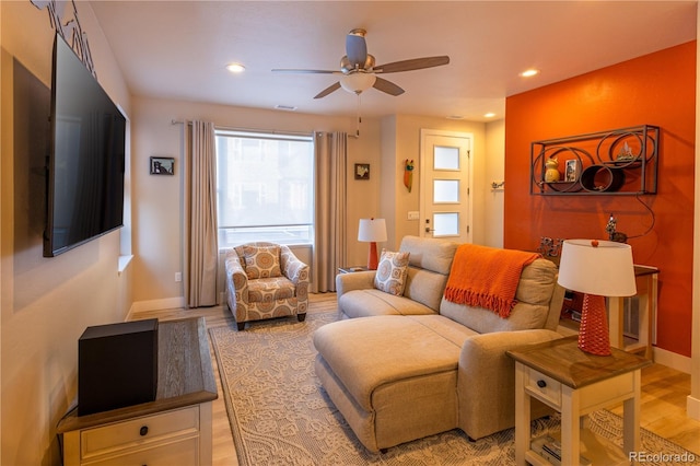 living room with ceiling fan and light hardwood / wood-style floors