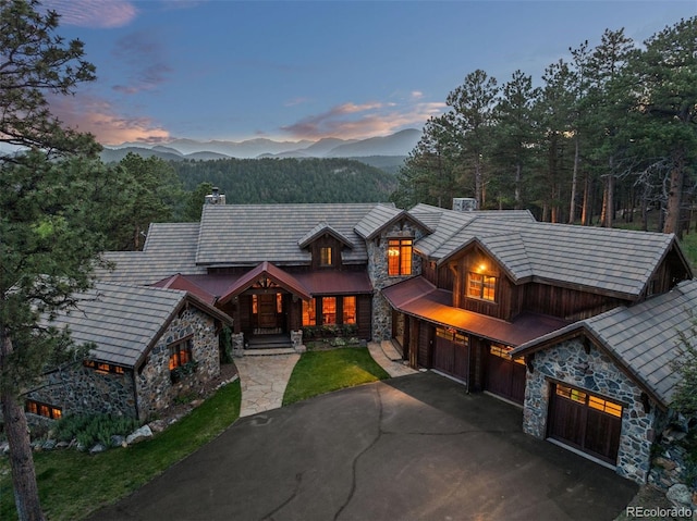 2929 Highlands View Rd, Evergreen, CO 80439 - chalet / cabin with stone siding, a chimney, driveway, a garage, and a mountain view