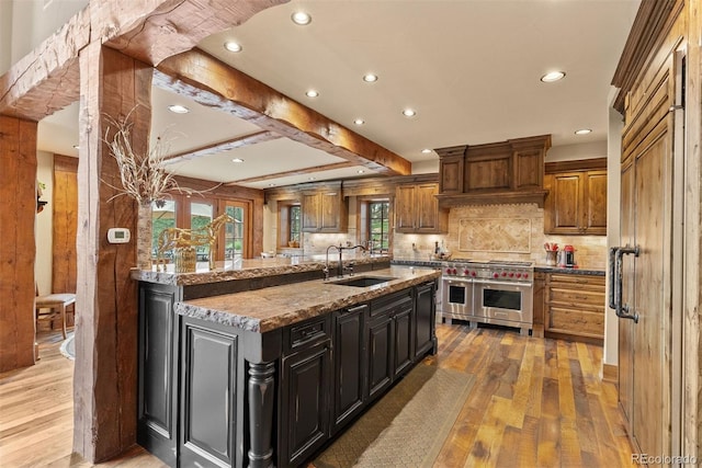 2929 Highlands View Rd, Evergreen, CO 80439 - kitchen with double oven range, light wood-type flooring, recessed lighting, backsplash, and light stone countertops
