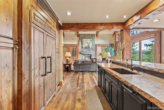 2929 Highlands View Rd, Evergreen, CO 80439 - kitchen with light wood finished floors, beamed ceiling, recessed lighting, dark cabinets, and open floor plan