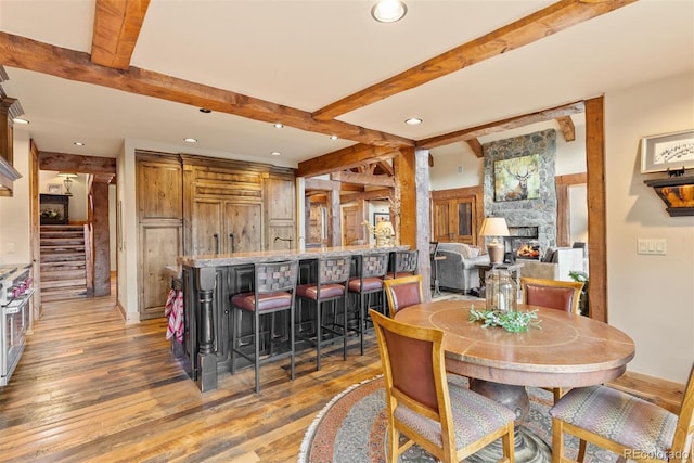 2929 Highlands View Rd, Evergreen, CO 80439 - dining space featuring beamed ceiling, wood finished floors, recessed lighting, bar area, and stairs