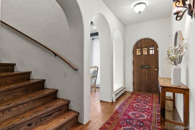 50 Albion St, Denver, CO 80220 - foyer featuring a baseboard radiator, arched walkways, stairway, wood finished floors, and a textured wall
