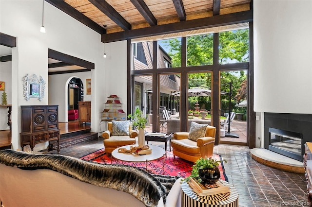 50 Albion St, Denver, CO 80220 - living room featuring a high ceiling, a glass covered fireplace, and a wooden ceiling with exposed beams