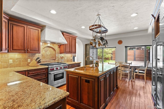 50 Albion St, Denver, CO 80220 - kitchen featuring premium range hood, luxury range, wood-type flooring, a center island with sink, and a textured ceiling