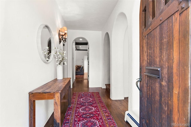 50 Albion St, Denver, CO 80220 - hall featuring a baseboard radiator, arched walkways, and dark wood-style flooring