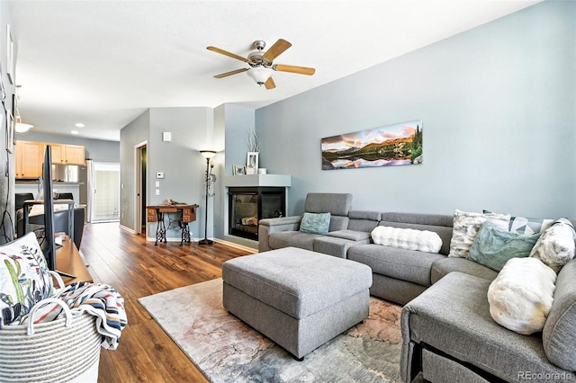 15612 E 96th Way Unit 20B, Commerce City, CO 80022 - living area featuring a glass covered fireplace, dark wood-type flooring, and ceiling fan