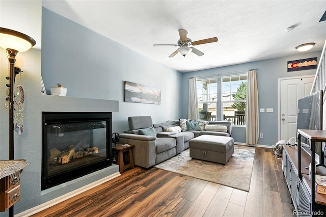 15612 E 96th Way Unit 20B, Commerce City, CO 80022 - living area with wood finished floors, a ceiling fan, and a glass covered fireplace
